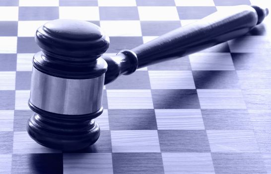 Judges gavel on top of a chess board