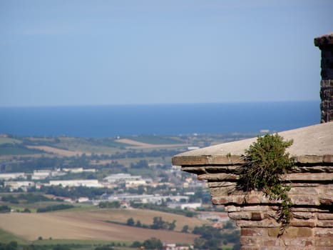 Beautiful panoramic view of fields of Italy with a high tower of the church