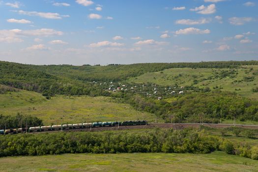 Freight Train Going by Railway Against Summer Landscape