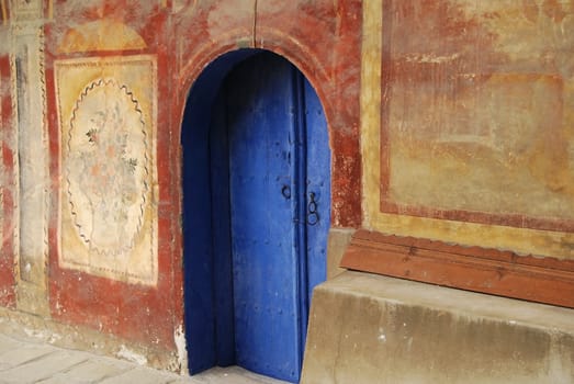 Indigo blue monastery wooden church door, painted wall