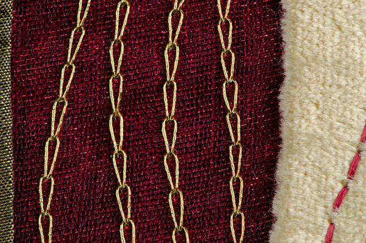 A red cloth texture with strong contrast and lines with golden decorative chains.