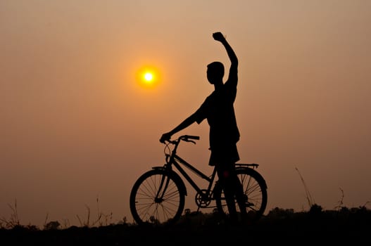 silhouette of boy happy with bicycle