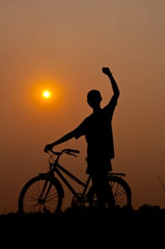 silhouette of boy happy with bicycle