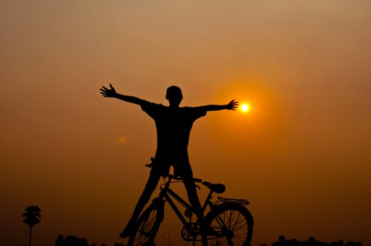 silhouette of boy happy with bicycle