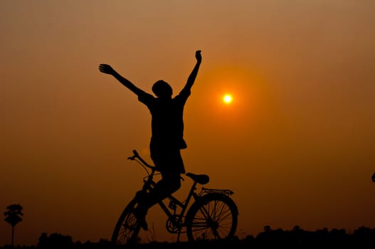 silhouette of boy happy with bicycle