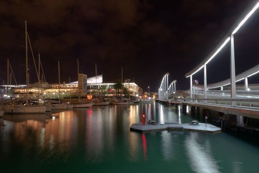 night walkway the Rambla de Mar, Port Vell in Barcelona, Spain