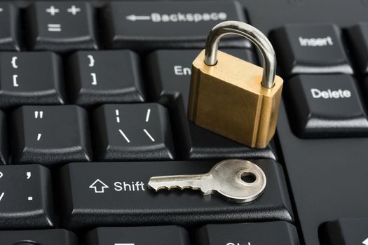Padlock on the computer keyboard. Safety concept with key