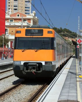 Modern orange train on station. Barcelona, Spain.