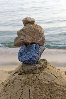 Stone tower on sand sea beach concept