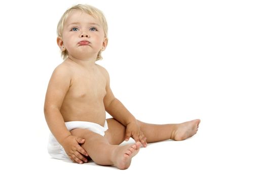 Blue eyed baby girl in huggies with no care face expression. Isolated on white background.