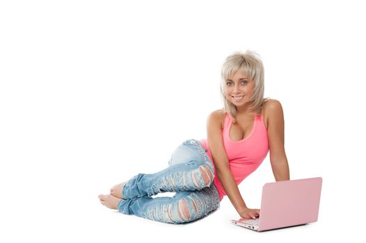 girl in a pink shirt, blue jeans sitting with a laptop