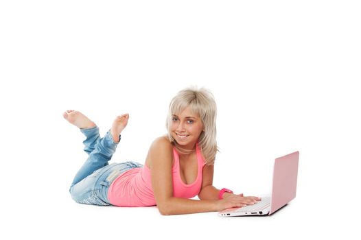 girl in a pink shirt, blue jeans lying with a laptop