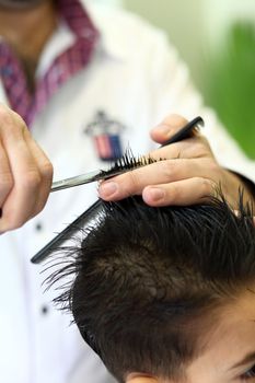 A lovely child in the hairdresser salon cutting his hair