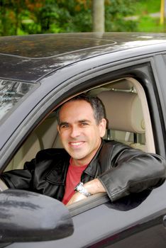 Smiling happy man looking from a car window