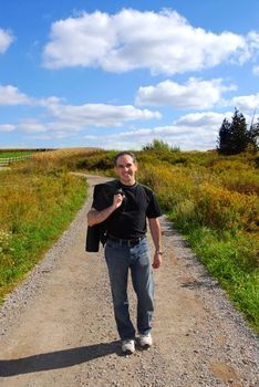 Smiling man walking on a country road