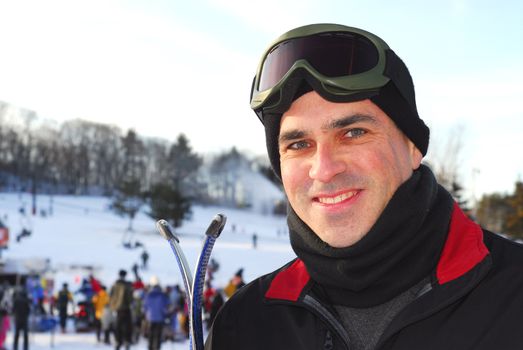 Portrait of a happy attractive man on downhill ski resort