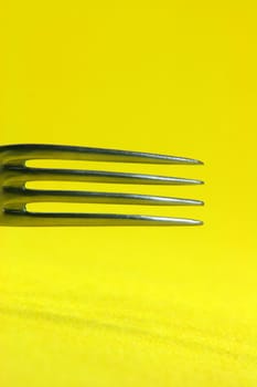 food and reasturants concepts fork detail in yellow background