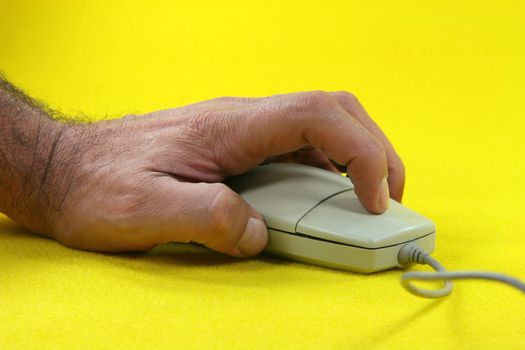 hand clicking a mouse in yellow background