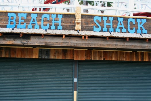 Close up of a beach shack sign and a totem pole.
