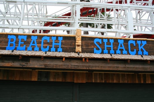 Close up of a beach shack sign and a totem pole.
