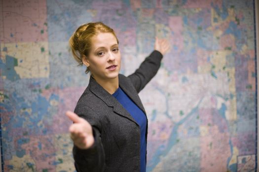 Young woman giving real estate presentation with map