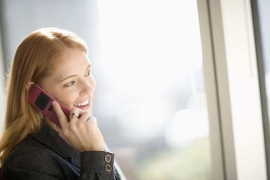 Young smiling businesswoman talking on cell phone
