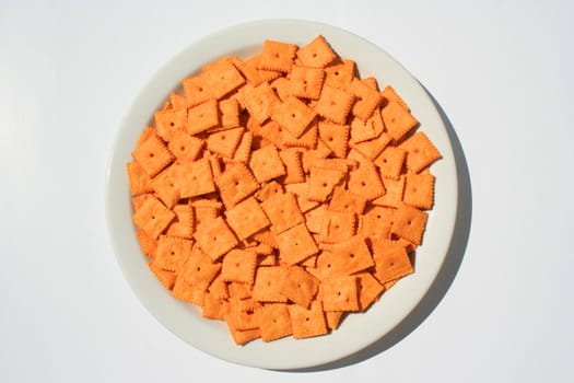 Close up of orange cheese crackers on a plate.
