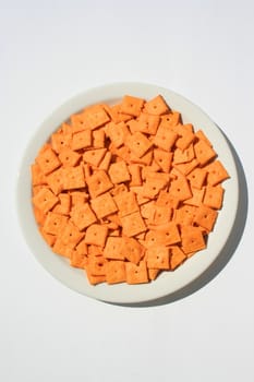 Close up of orange cheese crackers on a plate.
