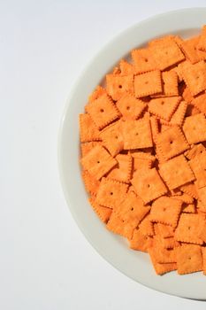 Close up of orange cheese crackers on a plate.
