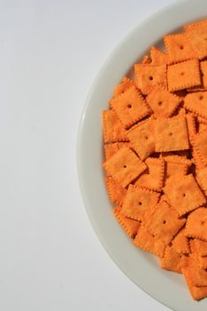 Close up of orange cheese crackers on a plate.
