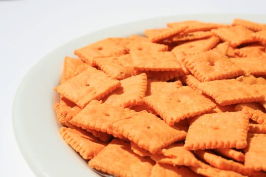 Close up of orange cheese crackers on a plate.
