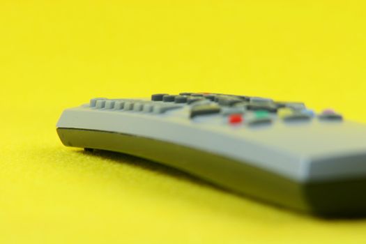 detail from television remote control in yellow background technology concepts