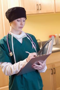 Female medical professional wearing surgical gear with medical chart