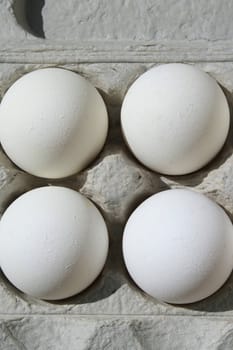 Close up of chicken eggs in a carton.
