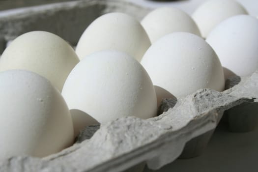 Close up of chicken eggs in a carton.
