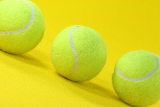 closeup three yellow tennis balls in yellow background sports concepts