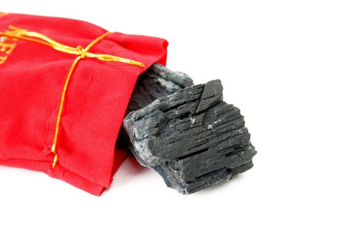 Lump of coal falling out of a Christmas sack.  Isolated on white with copyspace.