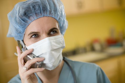 Woman surgeon talking on cell phone wearing surgical scrubs
