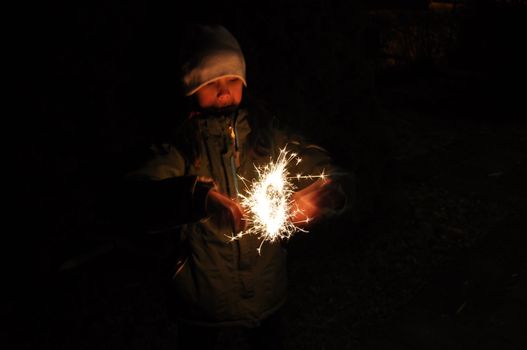 A girl holding a sparkler on new years eve.