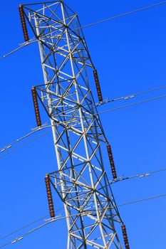 Electricity pylon over clear blue sky.
