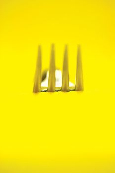 creative concept gourmet fork detail in yellow background vertical