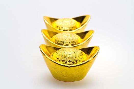 Three chinese gold ingots new year celebration on white surface