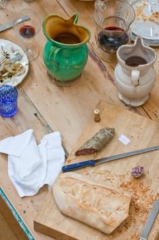 Bread, salame and wine inside a ceramic pitchers