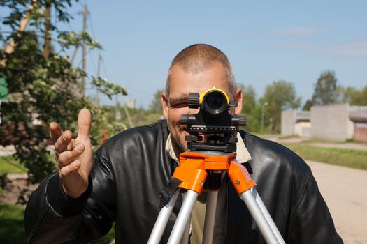 Surveyor measuring land for new street build.