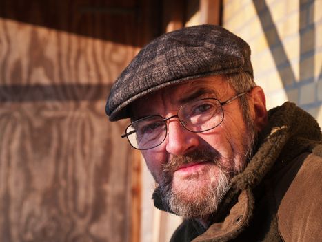 Closeup portrait of a happy smiling senior man with a hat outdoors 