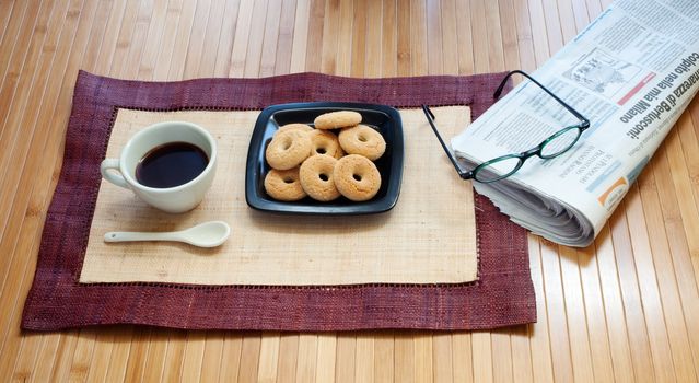 Breakfast with cookies coffee and newspaper
