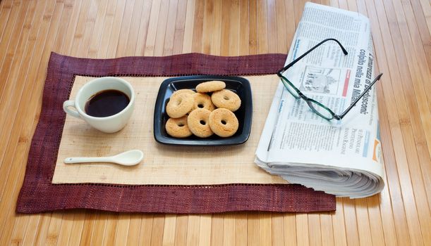 Breakfast with cookies coffee and newspaper