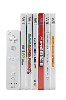 A studio shot of a stack of 6 Nintendo Wii video games and controller. Games include Donkey Kong Country Returns, The Legend of Zelda Twilight Princess, New Super Mario Bros. Wii, Super Mario Galaxy, Super Paper Mario, and Wii Fit Plus.