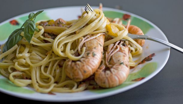 A fork of spaghetti with tomato sauce, basil and shrimp