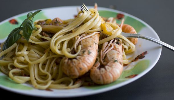 A fork of spaghetti with tomato sauce, basil and shrimp